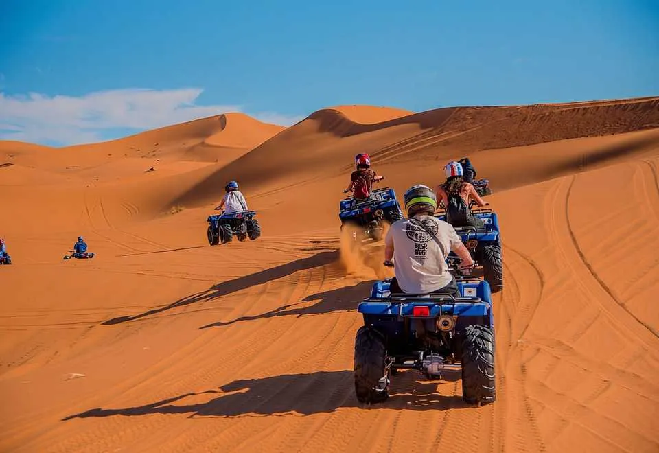 Quad bikes climbing the orange dunes of Erg Chebbi