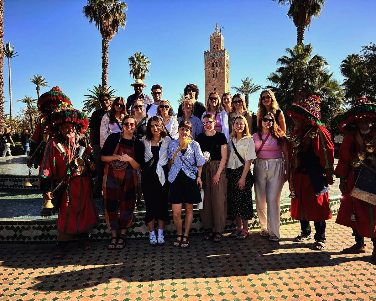 Student group with traditional water sellers in front of the Koutoubia Mosque, Marrakech