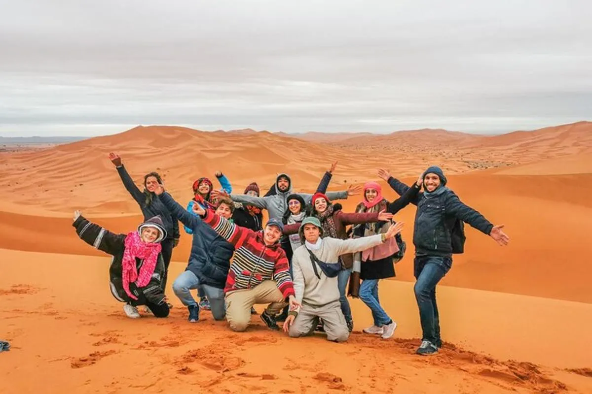 Student group cheering on top of the Merzouga dunes on a winter trip