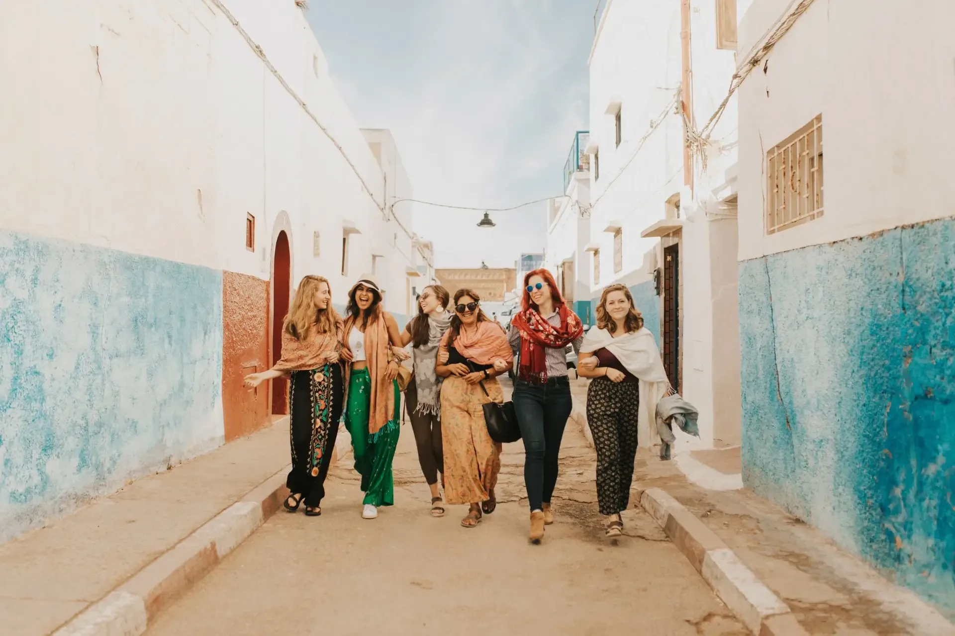 Students walking through the white and blue lanes of the Kasbah of the Udayas in Rabat